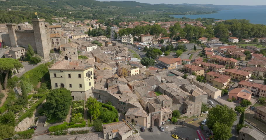 Aerial view of the medieval old town of Bolsena, in the province of Viterbo, Lazio, Italy, with stone houses, tiled roofs and the lake in the background. It