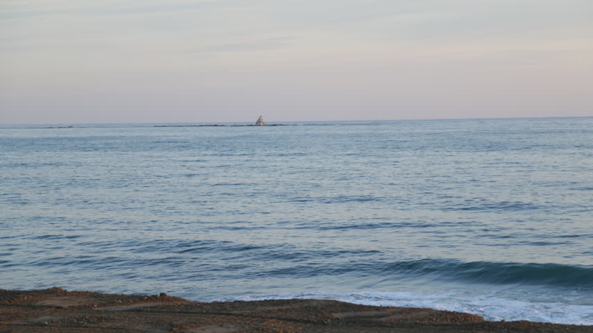 Dawn over the sea at Chigasaki. Shot of the calm sea at dawn in Chigasaki Shonan Japan with stand up paddle boarders and Eboshi rock