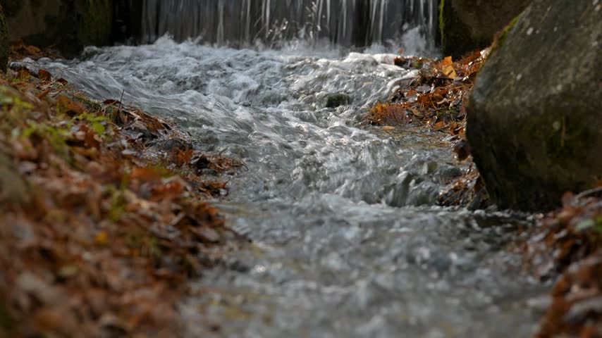 A small waterfall on the river in the autumn Park
