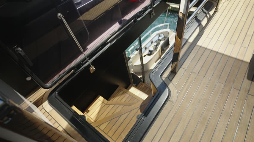 Wooden Staircase Leading to the Lower Deck of a Luxury Yacht on a Sunny Summer Day