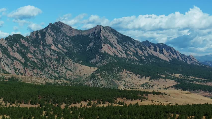 Aerial drone view South Boulder vista of the The Flatirons Colorado summer fall autumn morning sunny blue sky Front Range Rocky Mountains Foothills City of Boulder nature landscape forward motion