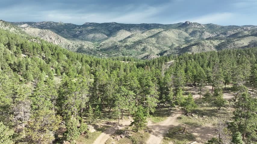 Mountain tops in Roosevelt National Forest epic drone vistas with pine forests and dramatic skies.