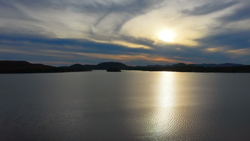 Lake at sunset in the Adirondack Mountains, aerial flyover shot, Speculator, NY. 4K