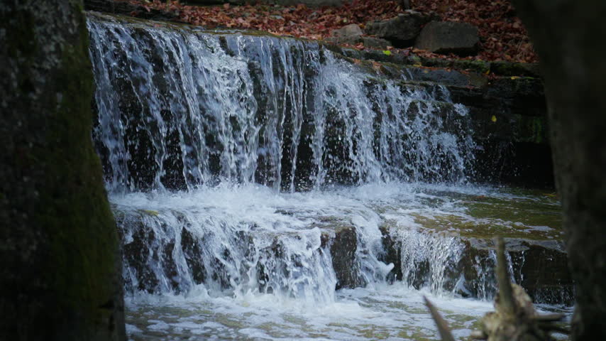 A small waterfall pours over stepped stone shelves in Rockway Falls, Ontario. High speed recording separates glistening water ribbons and swirling mist.
