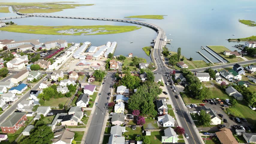 curved bridge crosses coastal water beside Chincoteague homes and salt marshes.