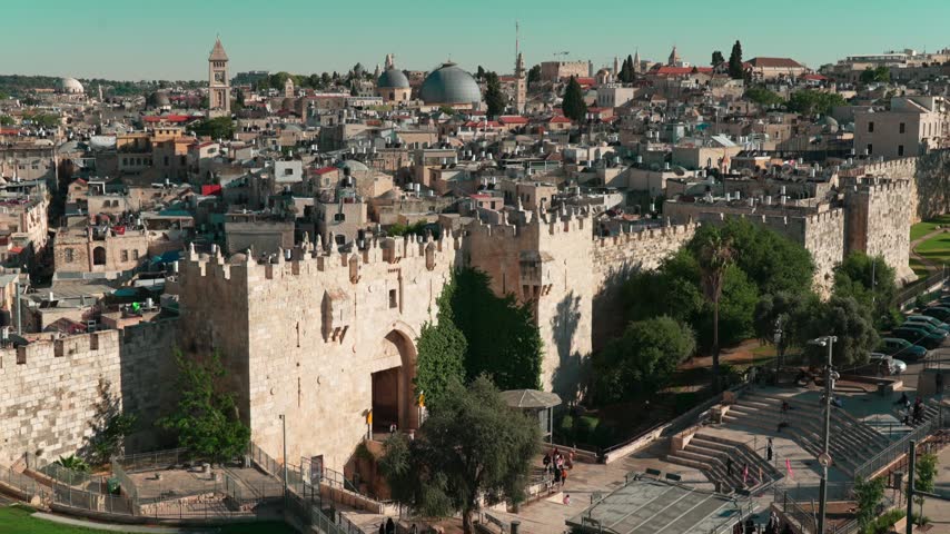 An afternoon view of Damascus gate at the old city of east Jerusalem, where Mosques and Churches, are intertwined with dense old houses, as filmed from a nearby rooftop. 