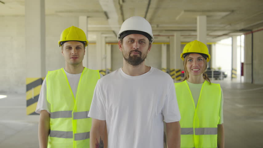 Chief engineer and electricians inspect a construction project inside an unfinished building