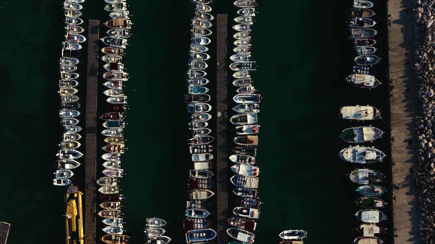 Top down drone view of boats moored in rows at piers in harbor, Corfu, Greece
