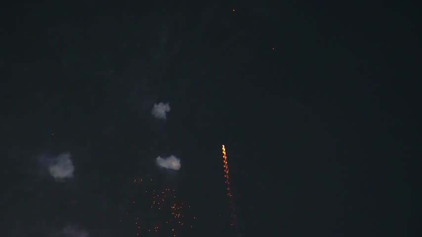 A single bright green fireworks burst expands dramatically across the night sky, producing numerous glowing points, radiating spark trails, and soft clouds of smoke. The vivid green illumination creates a striking nighttime celebration visual suitable for Diwali and Deepawali themes, New Year’s Eve, festivals, outdoor events, parties, entertainment, and festive backgrounds.