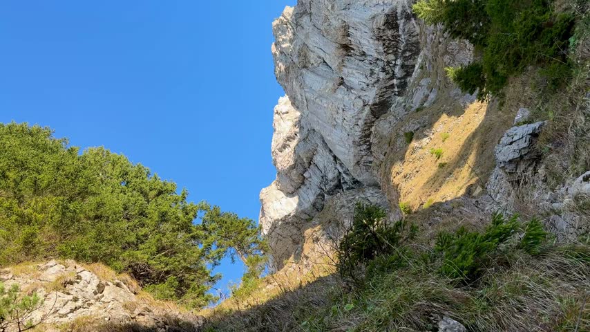 Steep rocky hiking trail ascending towards Mittaggüpfi mountain from Stäfeli near Eigenthal, Switzerland, with rugged alpine terrain and scenic mountain views on a sunny day.