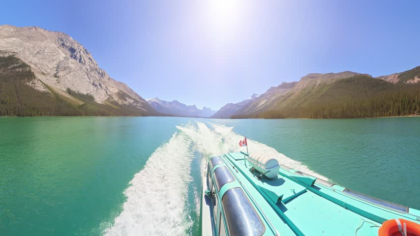 360 view of Tour boat cruising on Maligne Lake with Spirit Island, surrounded by dense evergreen forests and towering Rocky Mountains on summer in Alberta, Canada in Jasper National Park