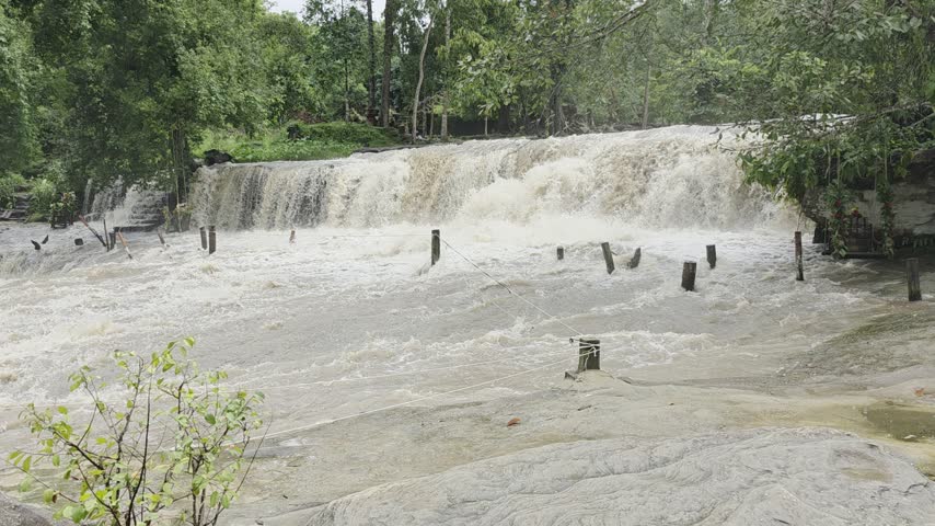 The raging waters of Phnom Kulen Waterfalls, overflowing its banks, Cambodia. 