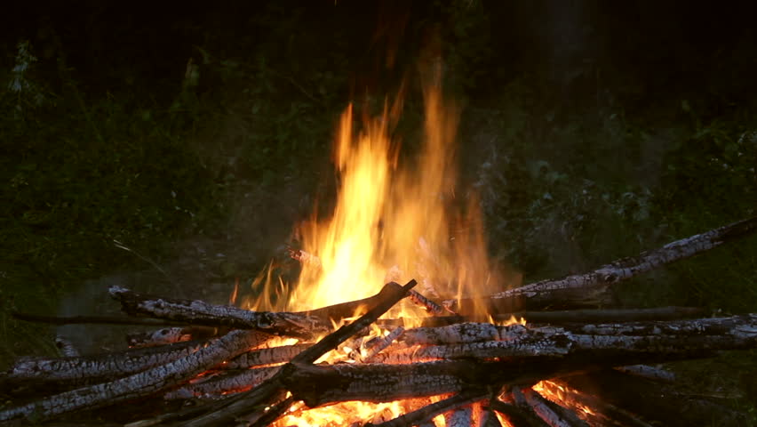 Men jumping over campfire