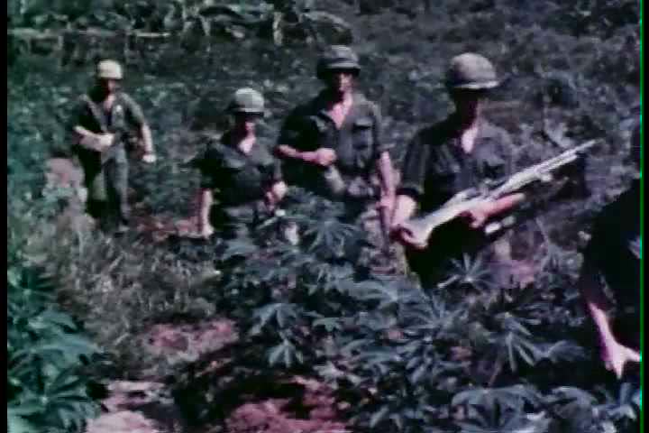 1960s - A group of Marines walk through the natural trials of Vietnam