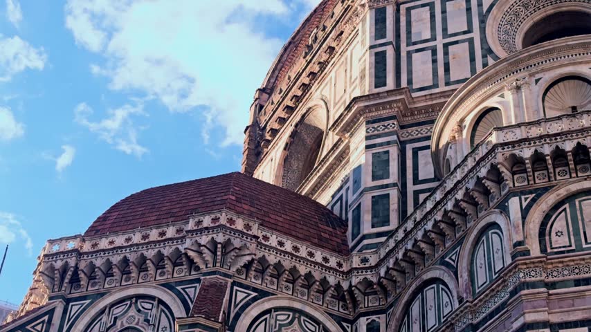 Architectural detail of the magnificent florence cathedral facade, known as santa maria del fiore, under a beautiful blue sky in tuscany, italy