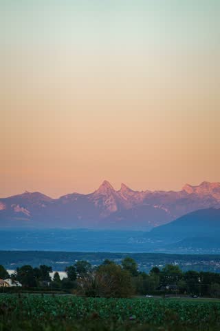 Full moon rising over distant mountains at twilight