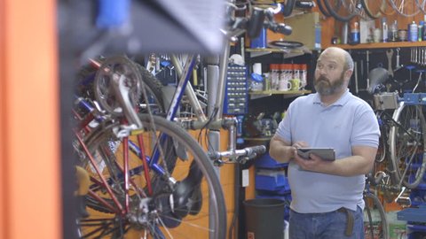 Man using digital tablet in bicycle workshop