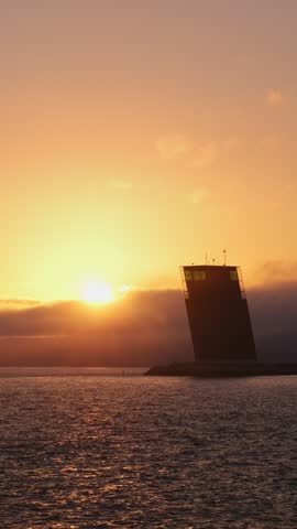 Torre VTS de Lisboa - VTS Vessel Traffic Systemtower - Centre for Coordination and Control of Maritime Traffic and Safety of Lisbon on bank of Tagus river, Portugal on sunset
