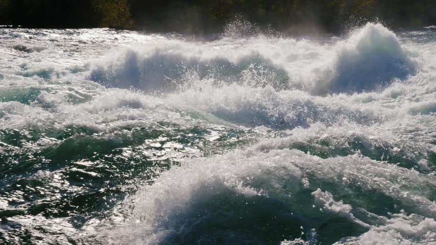 Whitewater rapids churning with intense foam and rushing currents in scenic outdoor river landscape.