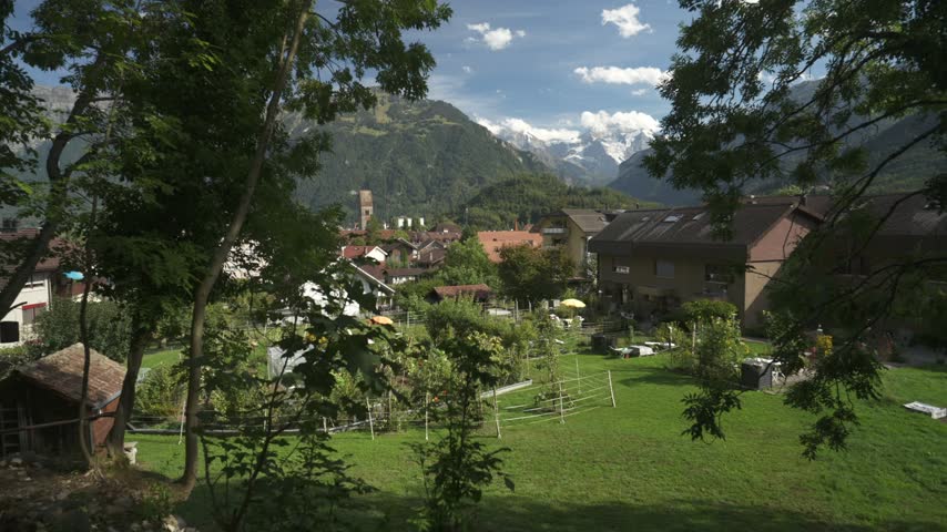Elevated view of Interlaken with snow covered Alps in background on a sunny day, Unterseen, Interlaken, Bernese Alps, Switzerland