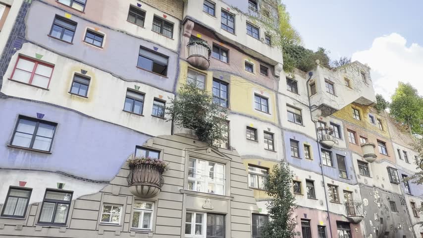 Colorful facade of the Hundertwasserhaus apartment building in Vienna, Austria, in a static wide shot.