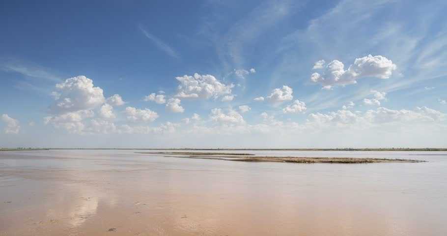 Time-lapse of Yellow River under pure blue sky with drifting white clouds and sandbars, Wuyuan County, Bayannur city, Inner Mongolia, China
