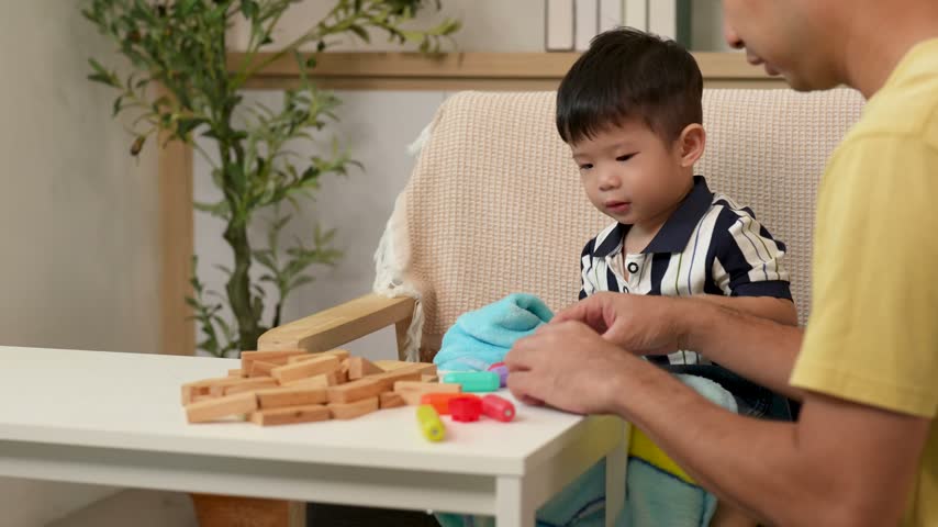 At home an adult and child play with colorful toys
