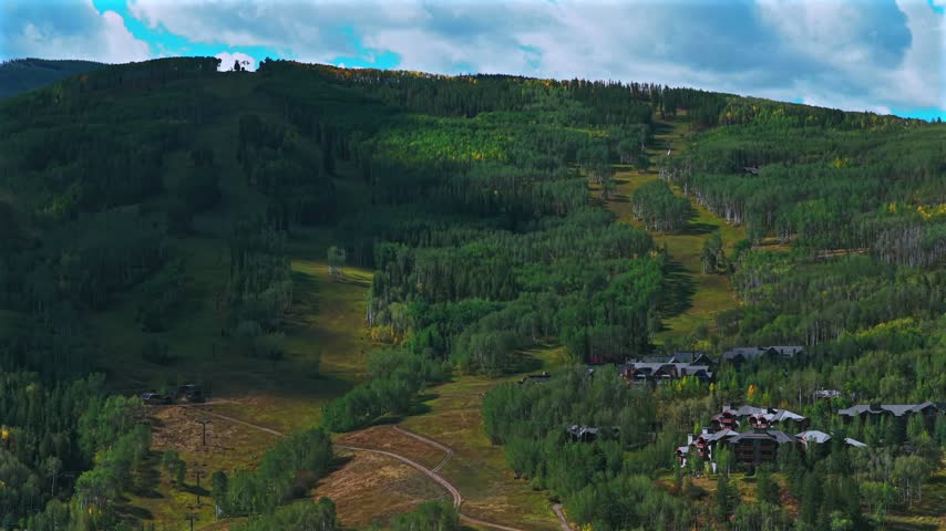 Aerial drone view of Beaver Creek Ski Resort ski trails sunny blue sky morning Fall Autumn Bachelor Gulch Vail Avon Colorado landscape Ritz Carton ski lodge buildings ski lift upwards motion