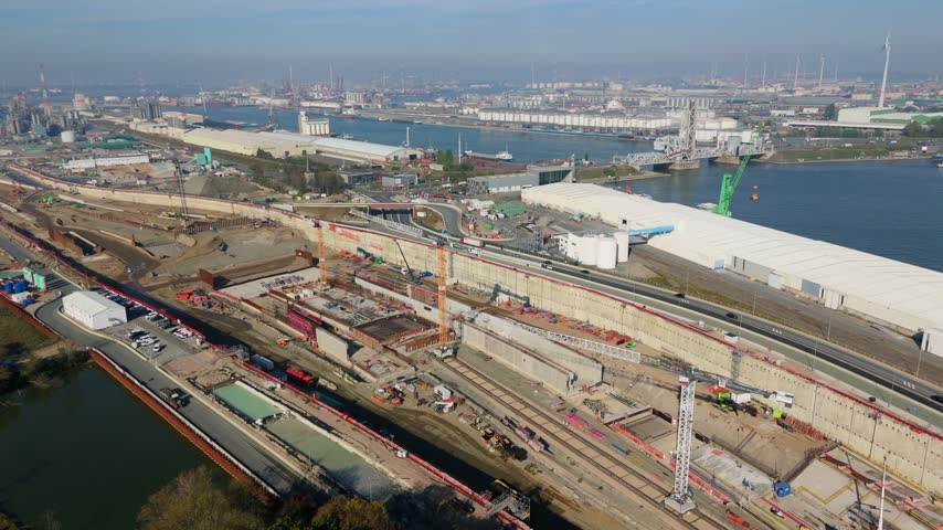 Aerial view large industrial construction site at Antwerp port with cranes and waterways