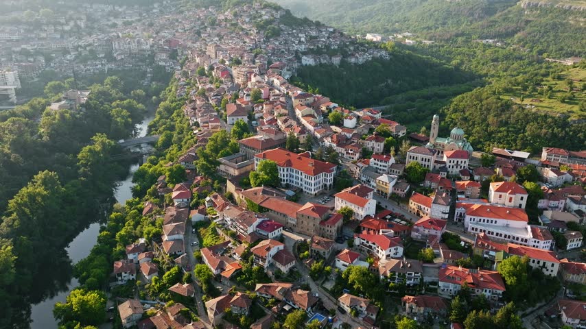 Veliko Tarnovo ancient town aerial view over Yantra River with red roof houses and green hills historical capital summer travel in Bulgaria stock footage