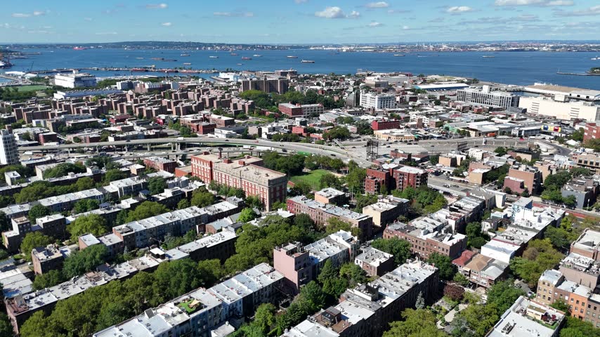 Aerial pan over Red Hook and the Gowanus Expressway toward Upper New York Bay and the Verrazzano Narrows Bridge, Brooklyn, New York City, USA.