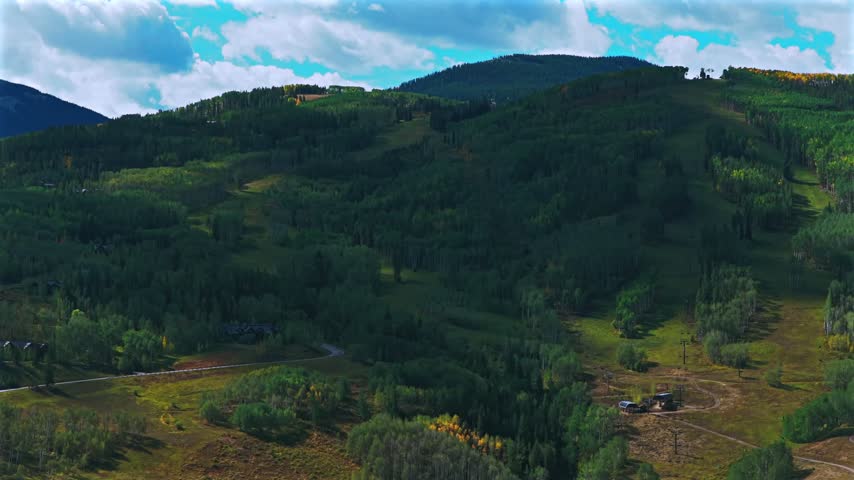 Aerial drone view of Beaver Creek Ski Resort ski trails ski lift sunny blue sky morning Fall Autumn Bachelor Gulch Vail Avon Colorado landscape Ritz Carton ski lodge buildings upwards motion