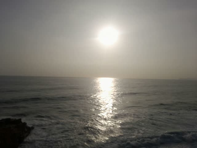Bright sun shining over ocean waves and calm horizon