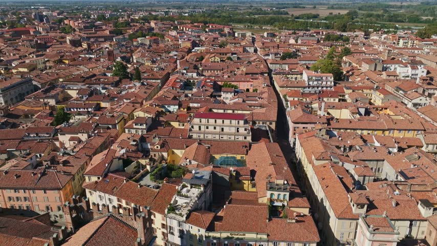 Aerial drone view of Piacenza city center, Italy, showcasing historic buildings, churches, terracotta rooftops, urban streets, and the charming Emilia-Romagna cityscape.