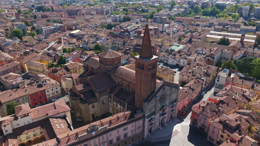 Aerial drone view of Piacenza Cathedral, Santa Maria Assunta e Santa Giustina, Italy, showcasing its historic façade, dome, bell tower, and surrounding old town.