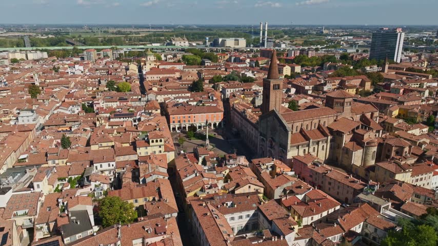 Aerial drone view of Piacenza Cathedral, Santa Maria Assunta e Santa Giustina, Italy, showcasing its historic façade, dome, bell tower, and surrounding old town.