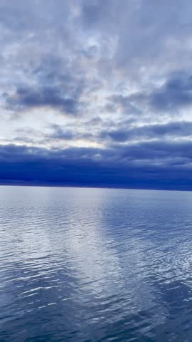 Gentle panoramic view of a blue lake beneath layered clouds