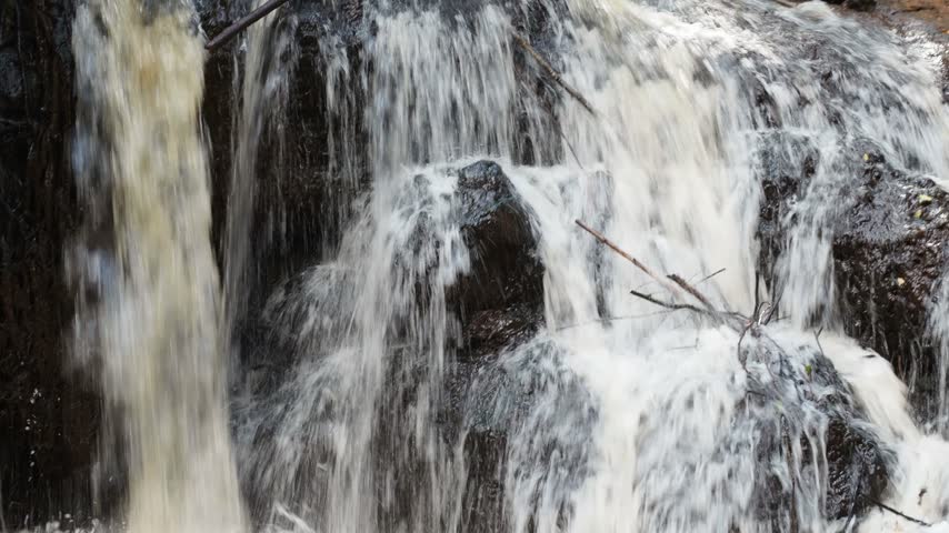 Closeup of a Waterfall Flowing Through the Rocks Detail
