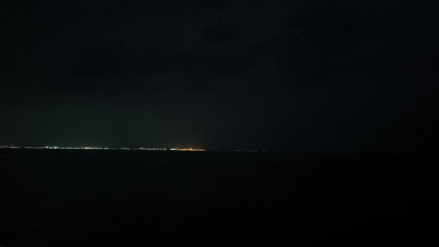 a ferry approaching the harbor at night