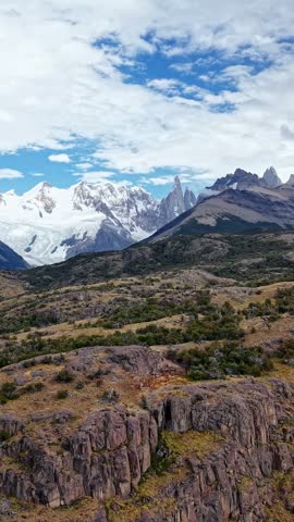 Rugged Mountain Landscape with Snow-Capped Peaks and Dry Grassland