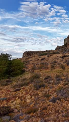 Rugged Rocky Landscape with Golden Grassland and Fence