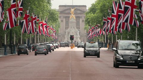 LONDON - JUNE 12:Traffic drives down The Mall towards Buckingham Palace with British flags along the road in preparation for the Trooping of the Colour on June 12, 2013 in London. 