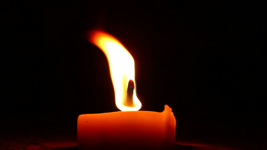 Shimmering light from burning candle at wind, open flame