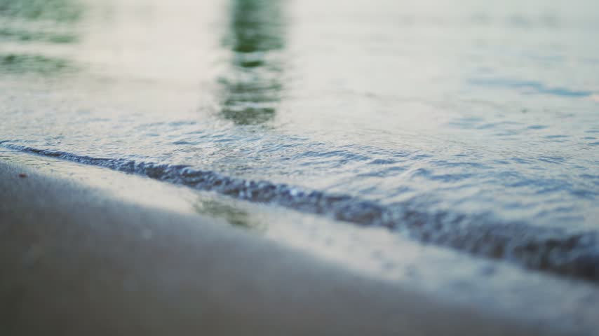 Small waves on sandy beach.