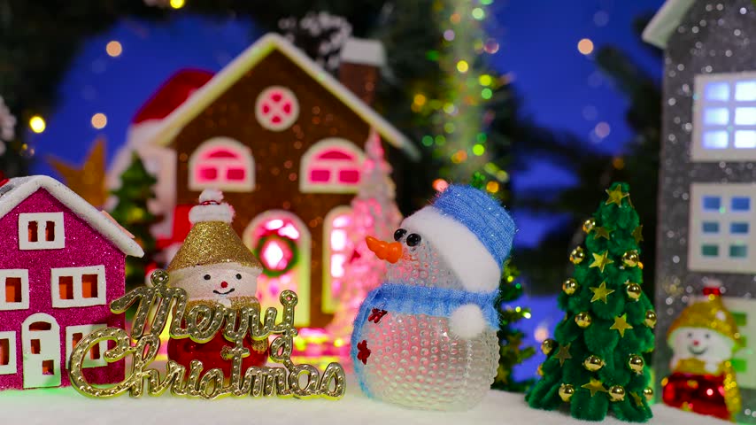 In a Christmas town, snowmen holding letters and a small house with a little fir tree are set against a backdrop of larger houses and a Christmas wreath