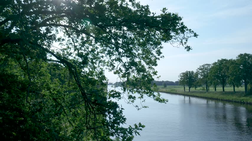 Calm water canal flowing through green countryside landscape