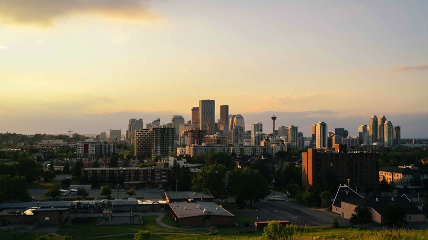 Sunset time-lapse over the Calgary skyline from a residential hillside as the golden sky fades to blue dusk, Calgary, Alberta, Canada