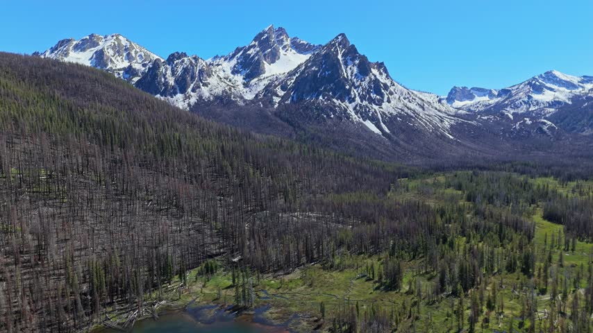 Aerial crane shot of McGowan Peak at Stanley Lake in Sawtooth National Recreation Area on a sunny day in spring.