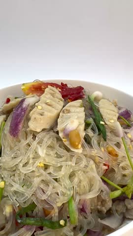 Vertical View of Thai Glass Noodle Salad with Pork Sausage, Tomato and Herbs
