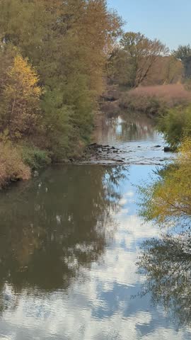 Time Lapse of water moving in a creek in the Midwest on a cloudy fall day with autumn leaf color. 
